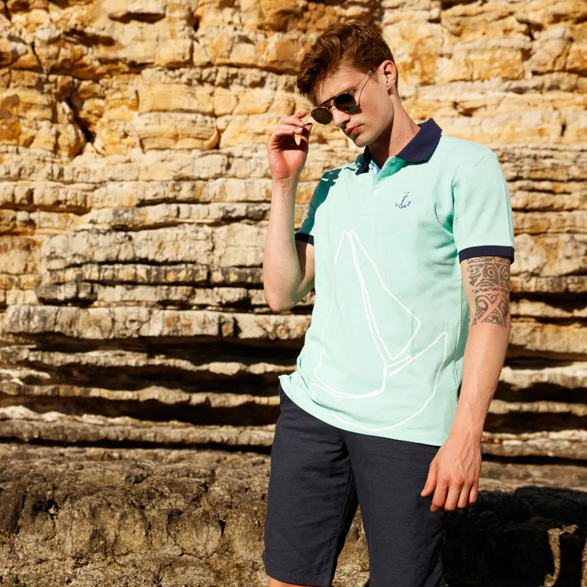 Men's Nautical Cotton Polo Shirt by Anemoss in mint green with black collar and sleeve trim, featuring an embroidered anchor logo on the chest and a large sailboat graphic across the fron
